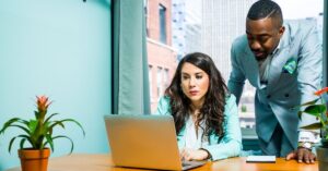 Two people discussing at a laptop